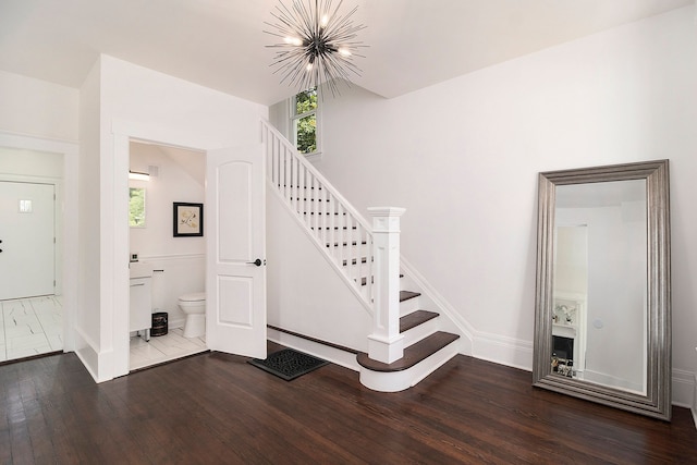 stairway featuring a chandelier, wood-type flooring, and plenty of natural light