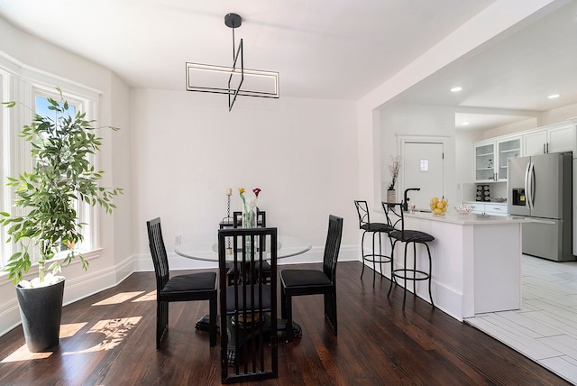 dining space with a healthy amount of sunlight, dark hardwood / wood-style flooring, and sink