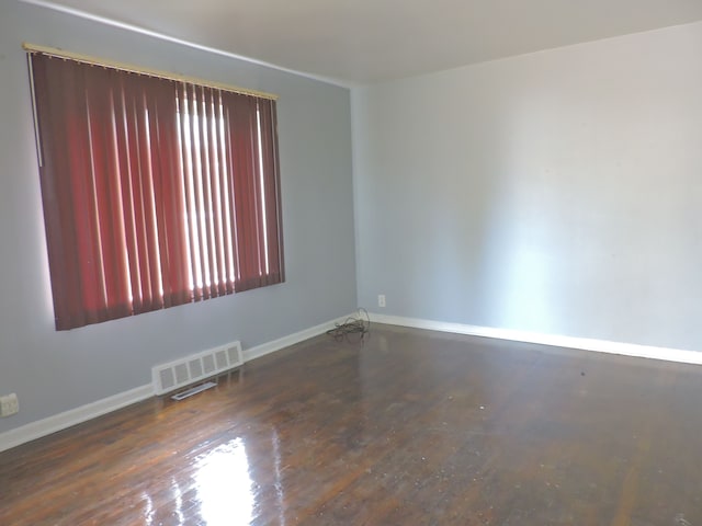 empty room with dark hardwood / wood-style flooring