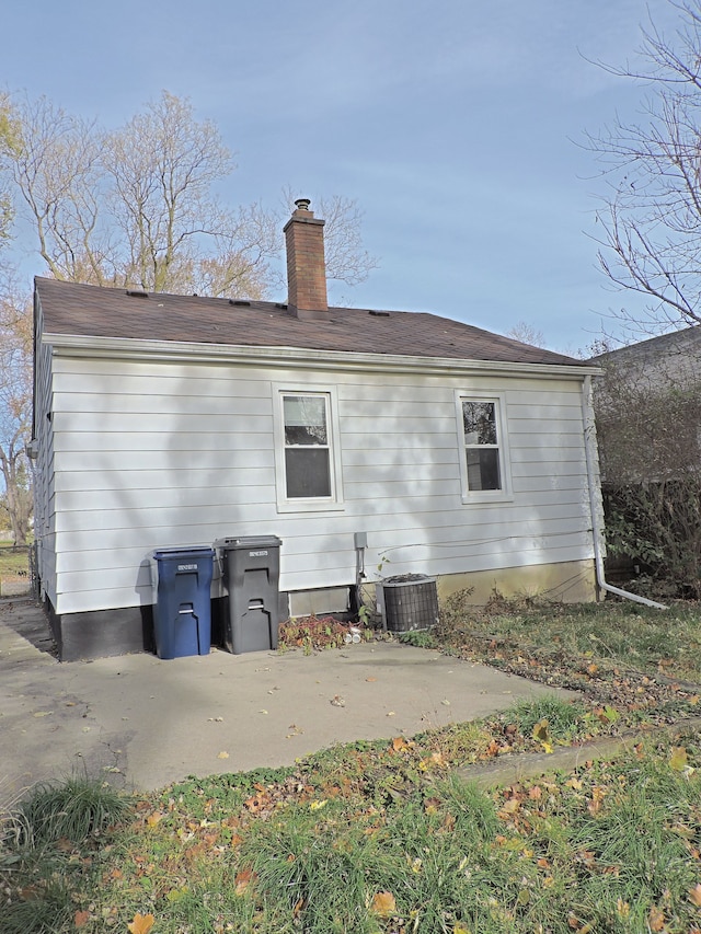 rear view of property with cooling unit and a patio area