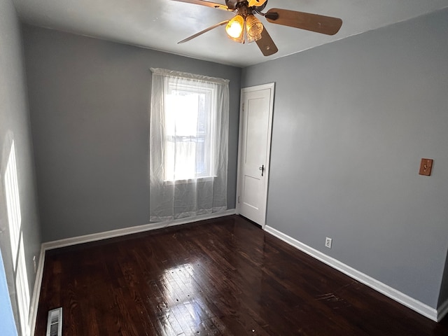 empty room featuring dark wood-type flooring and ceiling fan