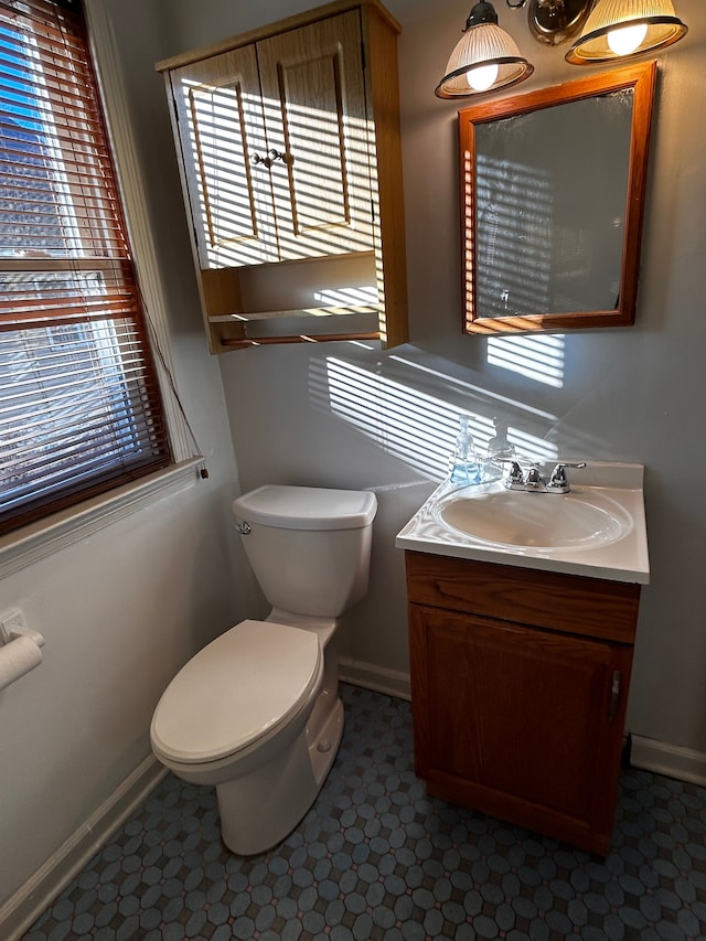 bathroom with vanity, toilet, and a healthy amount of sunlight