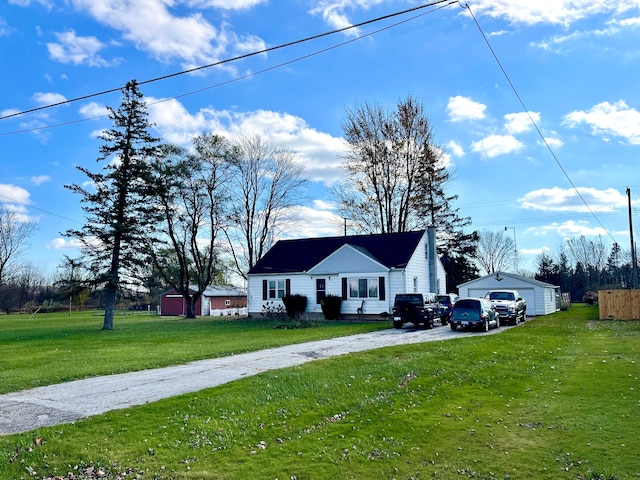 view of front facade with a garage, an outbuilding, and a front lawn