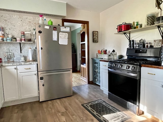 kitchen with appliances with stainless steel finishes, white cabinetry, and wood-type flooring