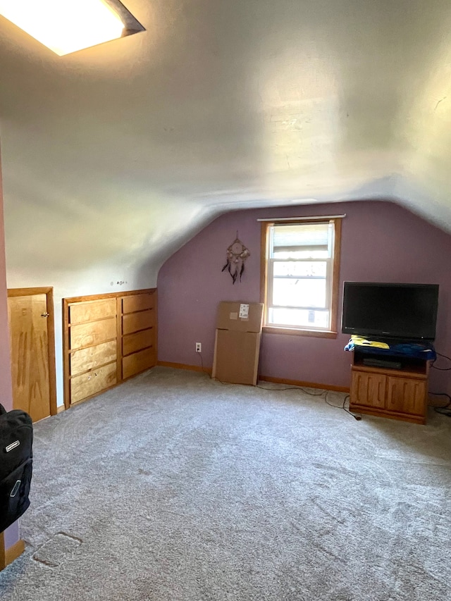 bonus room with light colored carpet and vaulted ceiling