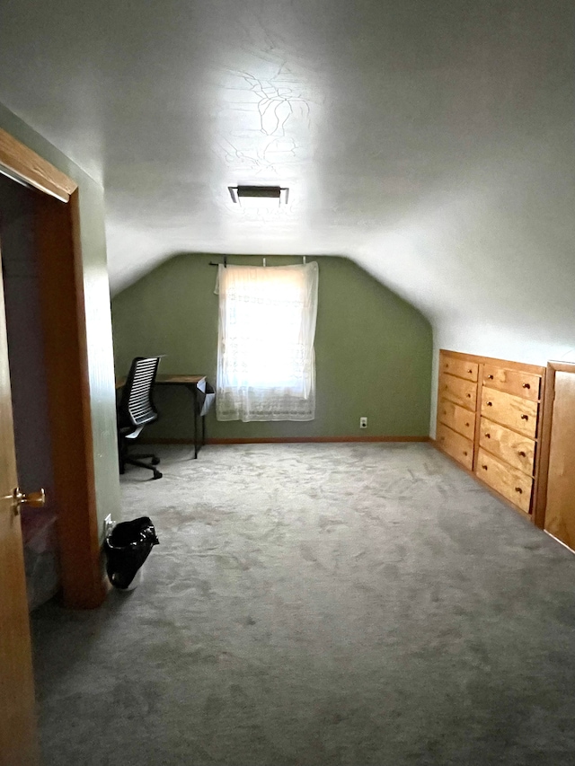 additional living space featuring carpet flooring and lofted ceiling