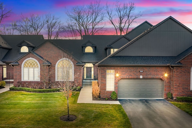 view of front of home with a garage and a lawn