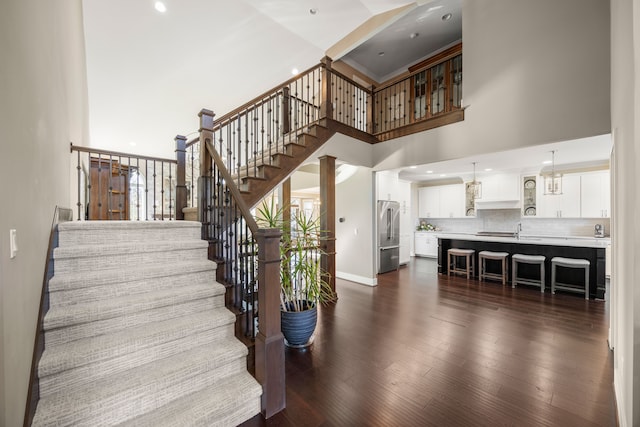 stairs with a high ceiling and hardwood / wood-style flooring