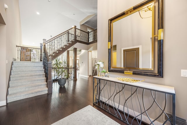 staircase with hardwood / wood-style flooring and a high ceiling