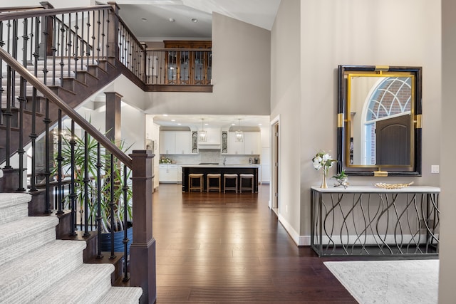 staircase featuring wood-type flooring, high vaulted ceiling, and a wealth of natural light