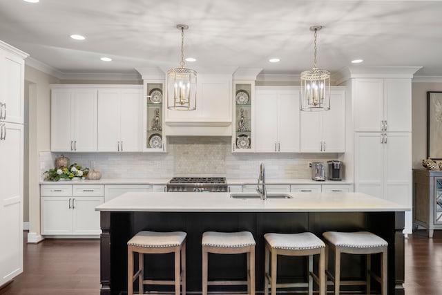 kitchen with dark hardwood / wood-style flooring, a kitchen island with sink, and sink