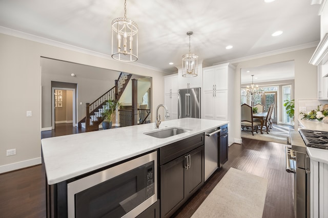 kitchen featuring appliances with stainless steel finishes, white cabinetry, pendant lighting, and sink