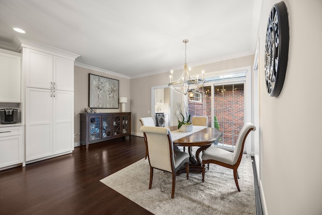 dining room with washer / dryer, crown molding, dark hardwood / wood-style flooring, and a notable chandelier