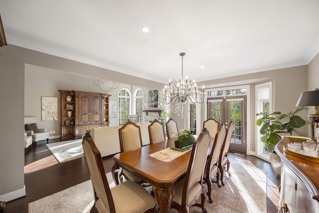 dining space with hardwood / wood-style flooring, a notable chandelier, ornamental molding, and french doors