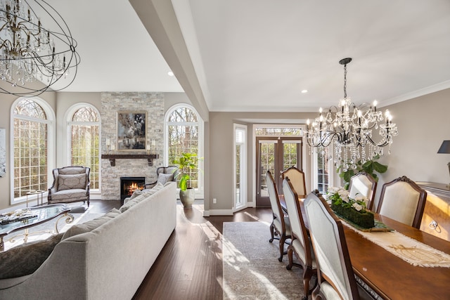 living room with ornamental molding, dark hardwood / wood-style flooring, a stone fireplace, and a healthy amount of sunlight