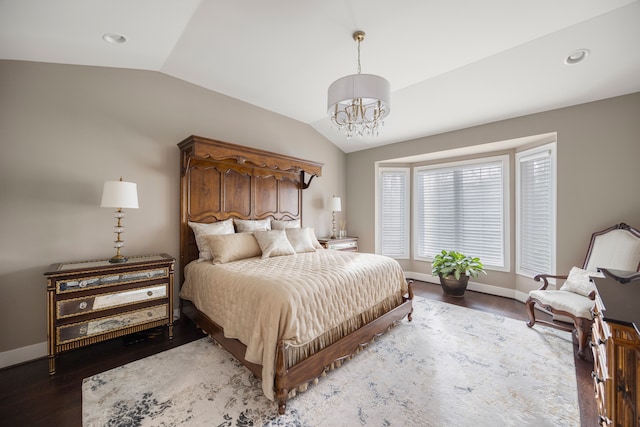 bedroom featuring wood-type flooring, an inviting chandelier, and vaulted ceiling