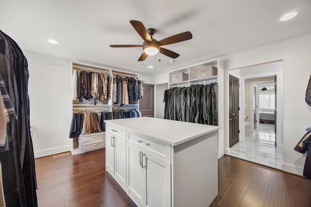 spacious closet with ceiling fan and dark hardwood / wood-style flooring