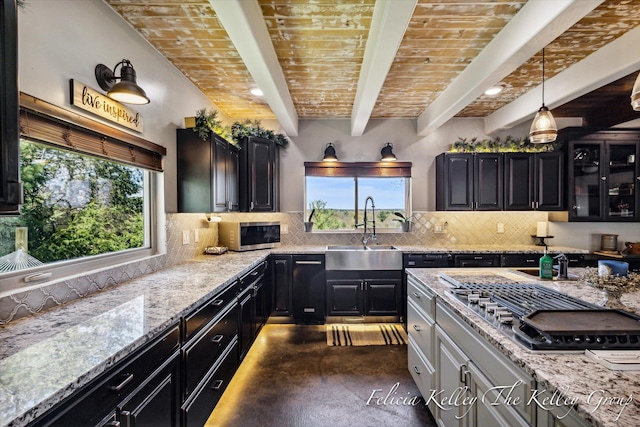 kitchen with beamed ceiling, a healthy amount of sunlight, sink, and hanging light fixtures