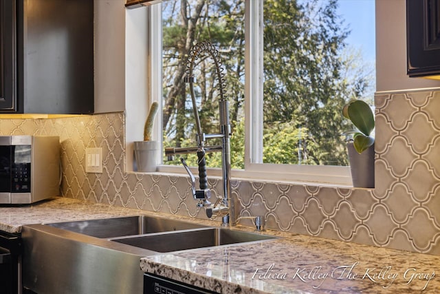 kitchen featuring light stone countertops and tasteful backsplash