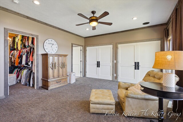 sitting room featuring carpet, ceiling fan, and crown molding