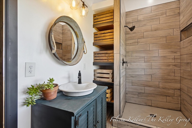 bathroom with a tile shower and vanity