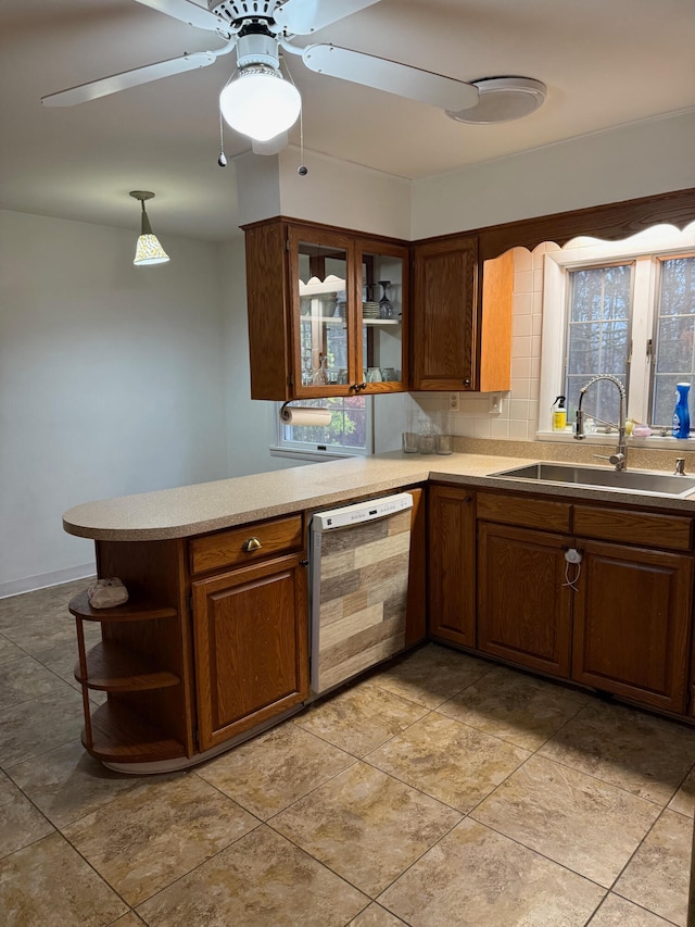 kitchen with pendant lighting, sink, ceiling fan, dishwashing machine, and kitchen peninsula
