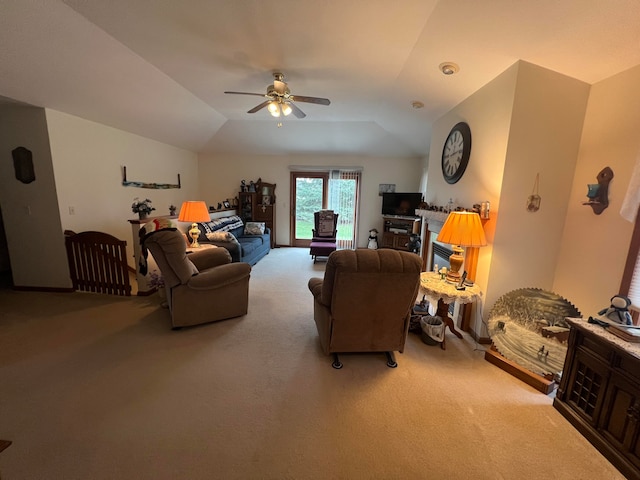 living room featuring carpet floors, a wood stove, ceiling fan, and vaulted ceiling