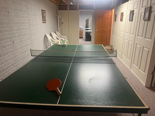 recreation room featuring brick wall