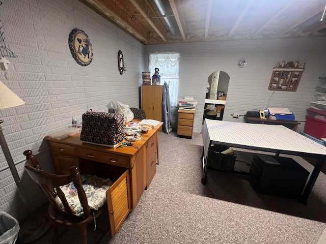 carpeted office space with brick wall