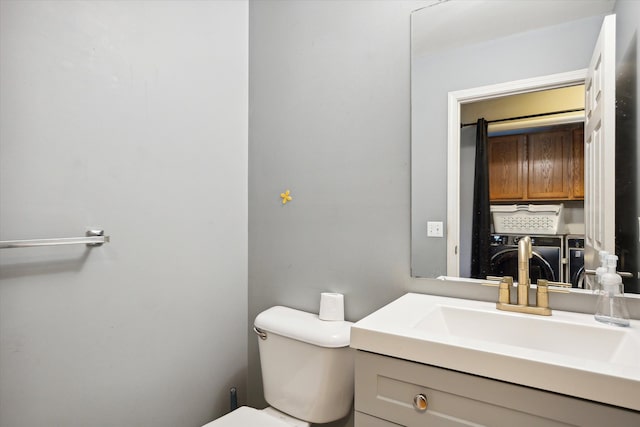 bathroom featuring vanity, toilet, and washer / dryer