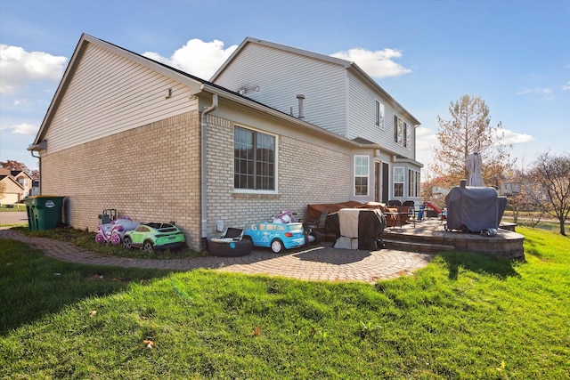 rear view of house featuring a yard and a patio