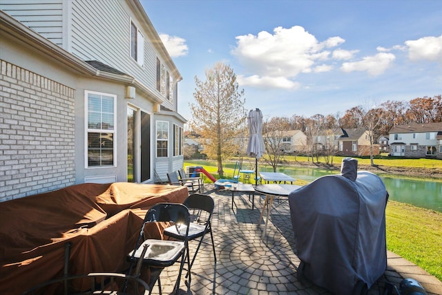 view of patio / terrace featuring grilling area and a water view