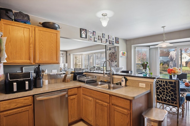 kitchen featuring dishwasher, kitchen peninsula, hardwood / wood-style flooring, and sink