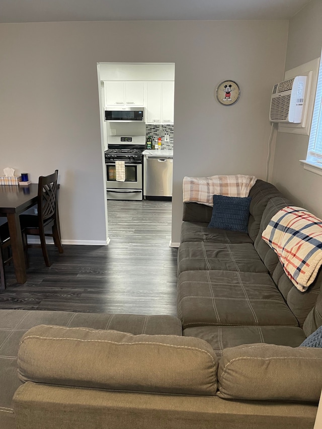 living room with dark wood-type flooring and a wall mounted AC