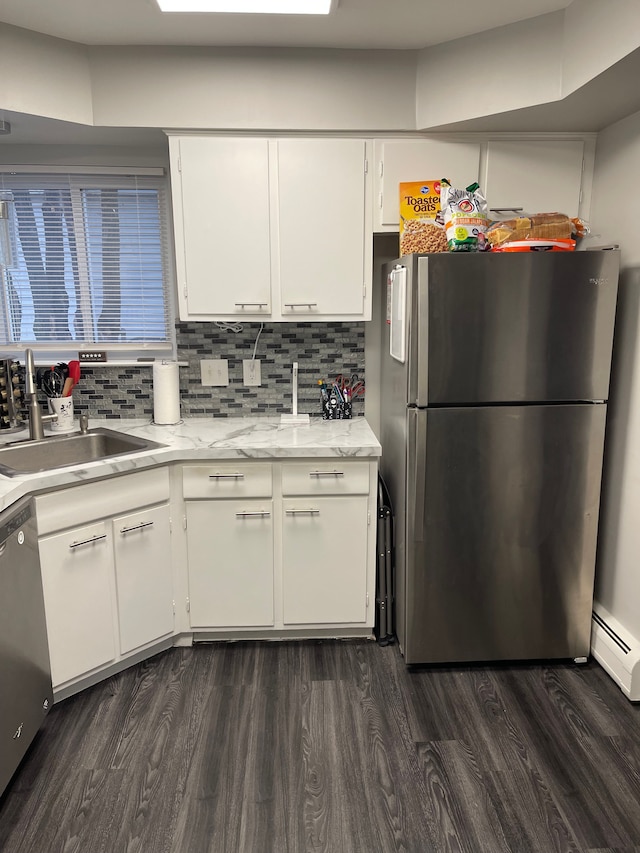 kitchen with white cabinets, appliances with stainless steel finishes, dark hardwood / wood-style floors, and sink