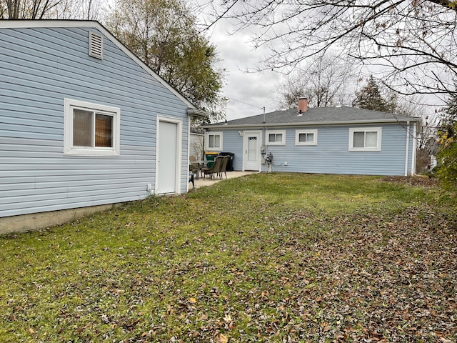 back of property featuring a patio area and a lawn