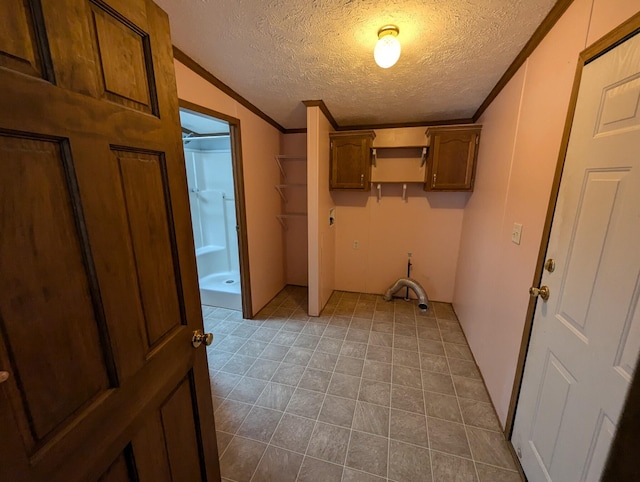 laundry area featuring electric panel, cabinets, a textured ceiling, and ornamental molding