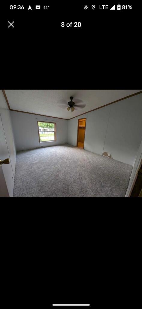 carpeted empty room featuring ceiling fan