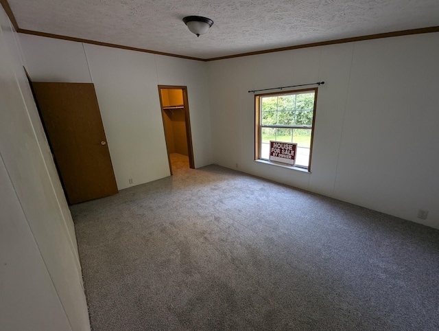 spare room with light carpet, a textured ceiling, and ornamental molding