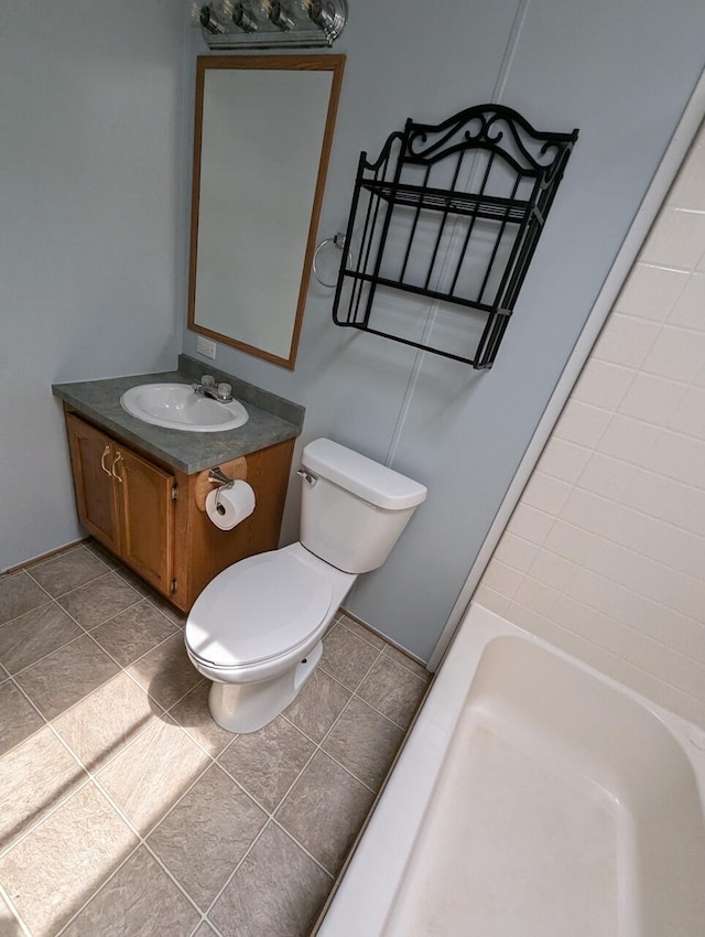 bathroom featuring tile patterned flooring, vanity, toilet, and a washtub