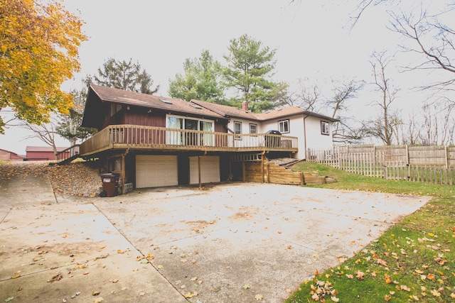 rear view of house with a garage and a wooden deck