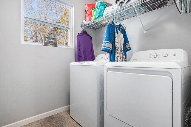 washroom with hardwood / wood-style flooring and washer and clothes dryer