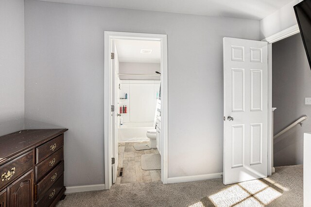 interior space featuring ensuite bath and light colored carpet