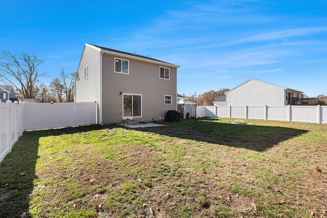 rear view of property featuring a lawn