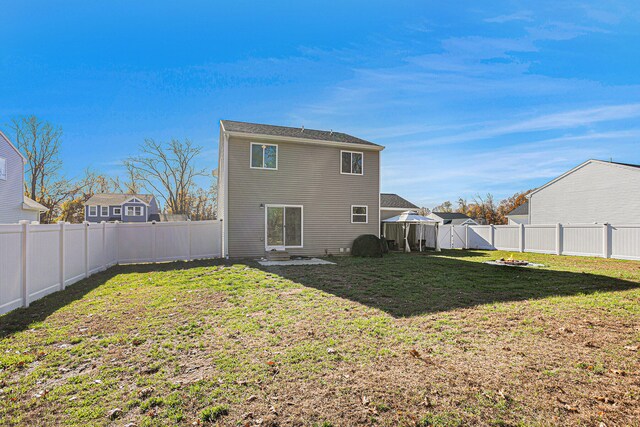 rear view of property featuring a yard