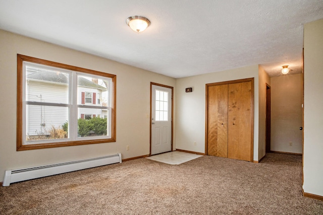 foyer with carpet, baseboard heating, and a textured ceiling