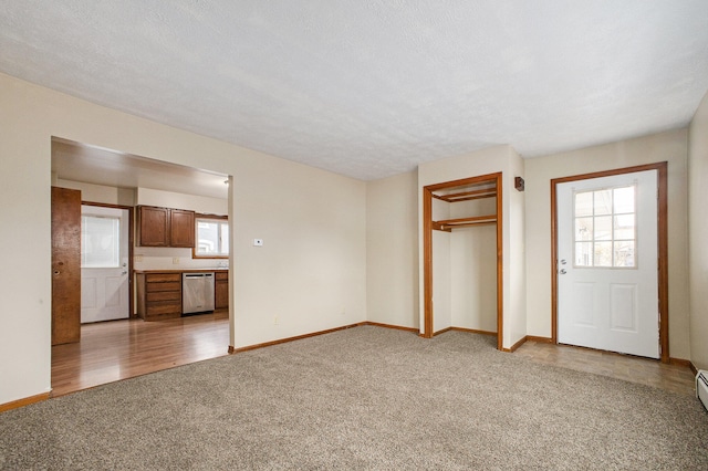 unfurnished living room with light hardwood / wood-style floors and a textured ceiling