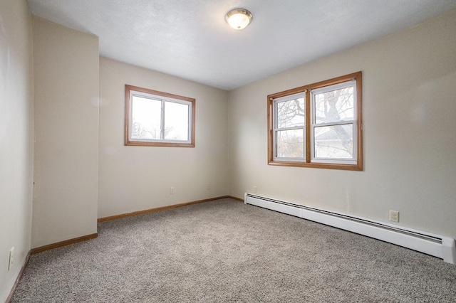 carpeted spare room featuring a wealth of natural light and a baseboard radiator