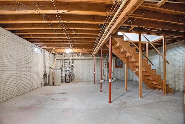 basement featuring brick wall and gas water heater