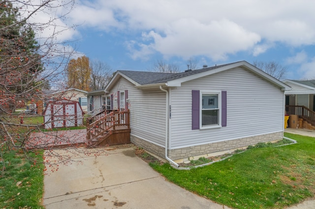 view of side of property featuring a yard and an outbuilding